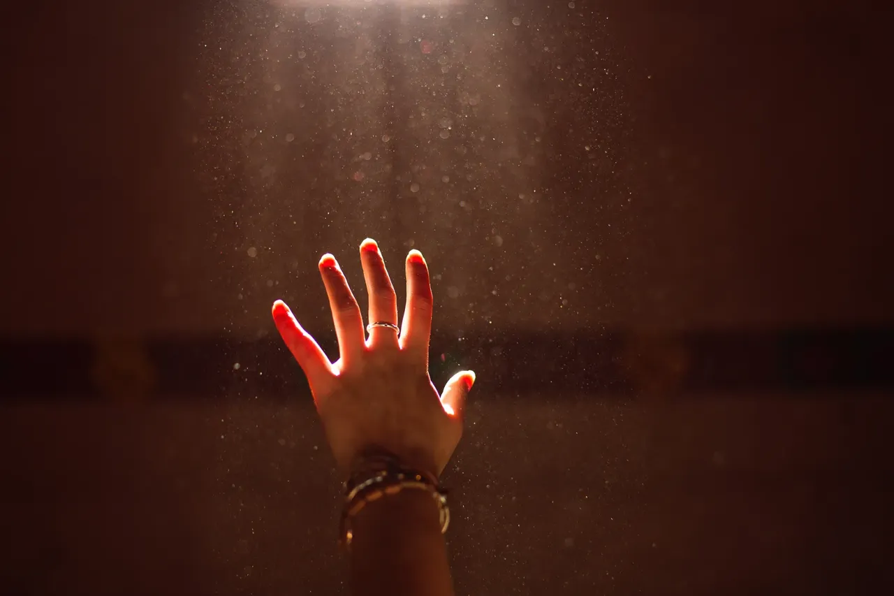 Die offene beschmu00fcckte Hand einer Frau wird durch das Sonnenlicht beleuchtet.